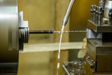 CNC torna makinesi delme aracıyla küçük şaft parçalarında bir delik açıyor. CNC dönüşüm makinesinin yüksek teknolojili metal işlemesi .