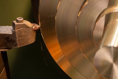 Closeup scene the lathe machine finish cut the brass parts by lathe tools. The metalworking process by turning machine.
