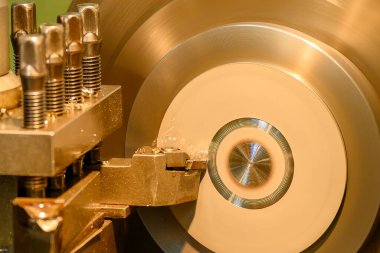 Closeup scene the lathe machine finish cut the brass parts by lathe tools. The metalworking process by turning machine.