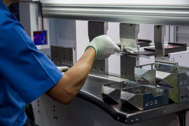 Bükme makinesini kapat. Metal parçaları tut ve güvenlik eldiveni tak. Yetenek operatörünün kullandığı levha metal çalışması.