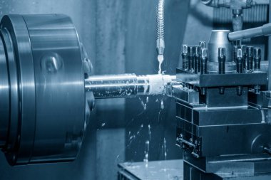 Torna makinesi metal şaft parçalarını sıvı soğutucu metoduyla kesiyor. Makineyi döndürerek metal işleme süreci.