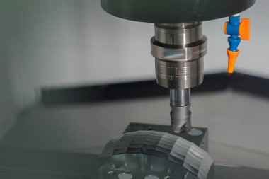 CNC değirmen makinesi açık mavi sahnedeki küf parçalarını ve G-kod veri arkaplanını kaba bir şekilde kesiyor. CNC makine merkezi tarafından üretilen kalıp ve ölüm süreci.