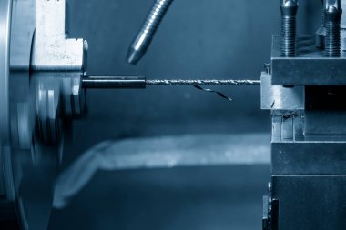 CNC torna makinesi delme aracıyla küçük şaft parçalarında bir delik açıyor. CNC dönüşüm makinesinin yüksek teknolojili metal işlemesi .