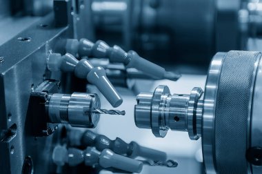 Çok görevli CNC torna makinesi metal şaft parçalarını deliyor. CNC dönüşüm makinesinin yüksek teknolojili metal işlemesi .
