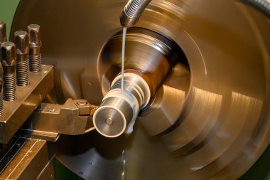 Torna makinesi metal şaft parçalarını sıvı soğutucu metoduyla kesiyor. Makineyi döndürerek metal işleme süreci.