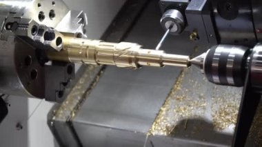CNC torna ya da dönme makinesi matkap aletleriyle pirinç şaftta delik açıyor. Yüksek teknoloji üretim süreci..