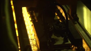 İçki fabrikasındaki üretim işlemleri için ısıtıcıya aktarılan plastik şişelerin ön biçimi. İçme suyu şişesi üretim süreci.