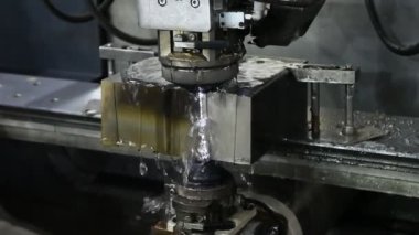  Kablo EDM makinesi soğutucu sıvıyla zarları kesiyor. CNC programı tarafından kablo kesme makinesiyle çalışan yüksek teknolojili metal işlem.