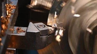 Torna makinesinin yavaş çekim sahnesi pirinç şaft malzemesini kesme işlemini tamamlıyor. Makineyi döndürerek metal işleme süreci.