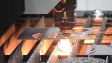 Işıltılı ışıkla metal plakayı oyan fiber lazer kesme makinesi. Lazer kesme makinesinin yüksek teknoloji metal üretim süreci..