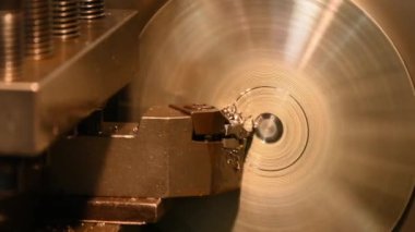 Torna makinesi torna malzemeleriyle metal parçaları kesiyor. Makineyi döndürerek metal işleme süreci.