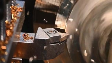 Torna makinesinin bitirdiği yavaş çekim sahnesi pirinç şaft parçalarını torna araçlarıyla kesiyor. Makineyi döndürerek metal işleme süreci.