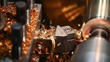 Ağır çekim sahnesi torna makinesi pirinç şaft parçalarını torna araçlarıyla kesmeyi bitirir. Makineyi döndürerek metal işleme süreci.