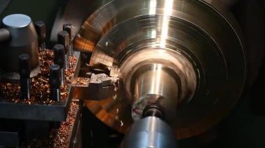 Torna makinesinin yavaş çekim yakın çekim sahnesi pirinç parçaları kesti. Makineyi döndürerek metal işleme süreci.