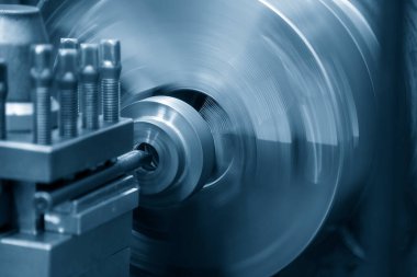Torna makinesi metal şaft parçalarını kesiyor. CNC dönüşüm makinesinin yüksek teknolojili metal işlemesi .