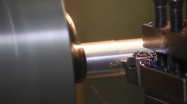 Torna makinesi sahneyi kapatır metal şaft parçalarını aletlerle keser. Makineyi döndürerek metal işleme süreci.