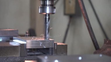 The drilling process on NC milling machine with coolant method. The metal working concept on the milling machine.