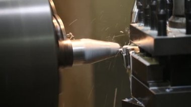 The lathe machine cutting the metal shaft parts with coolant method. The metalworking process by turning machine.