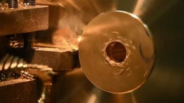 Ağır çekim sahnesi. Torna makinesi pirinç disk parçalarını kesmeyi bitirdi. Makineyi döndürerek metal işleme süreci.