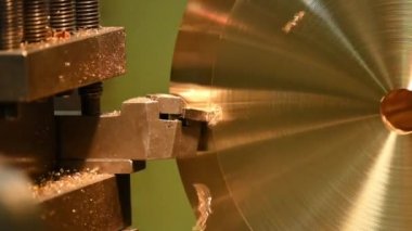 Torna makinesi, pirinç disk parçalarını torna ile kesmeyi bitirsin. Makineyi döndürerek metal işleme süreci.