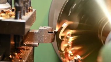 Torna makinesini kapat ve torna malzemesi parçalarını torna ile kes. Makineyi döndürerek metal işleme süreci.