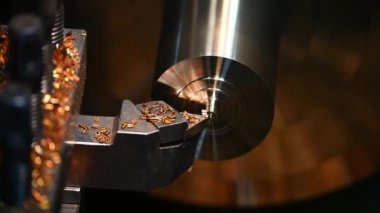 Yakından bakınca torna makinesi pirinç şaftı parçalarını kesmiş. Makineyi döndürerek metal işleme süreci.