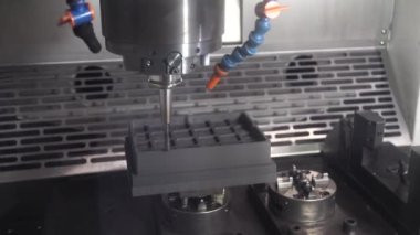 The CNC milling machine rough cutting the graphite electrode parts with solid ball end mill. The mold and die manufacturing process by CNC machining center.