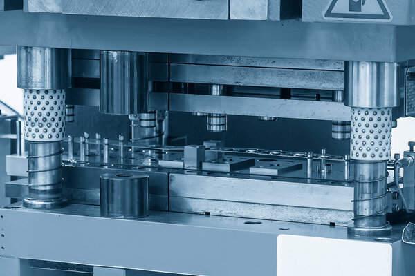 Крупный план прогрессивной операции в голубой сцене. Металлообрабатывающее оборудование для производственного процесса.