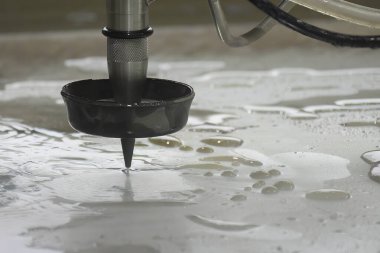 Çok eksenli yıpratıcı su jeti kesme makinesinin alüminyum plakayı kestiği yakın çekim sahnesi. CNC makinesiyle çalışan yüksek teknoloji levha metali.