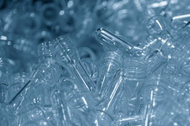 PET şişe ürünlerinin önceden biçimlendirilmiş hali yakın çekim sahnesi. Plastik şişe üretim süreci için hammadde.