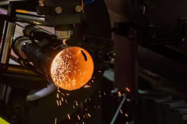 Sahneyi kapatın, fiber lazer kesme makinesi paslanmaz çelik tüpü kesti. Lazer kesme makinesinin yüksek teknoloji metal üretim süreci.. 