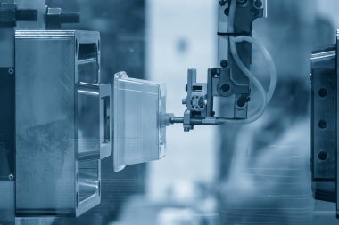Vakum robotik sistem tarafından tutulan kutu kabı parçası enjeksiyon sürecinden. Plastik enjeksiyon küf makinesinden otomatik sistem tarafından yapılan yiyecek kutusu üretim süreci.