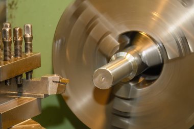 Torna makinesinin metal şaftı kestiği sahneyi kapatın. Makineyi döndürerek metal işleme süreci.