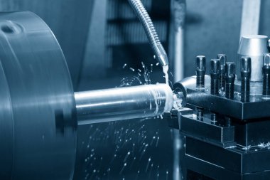 Torna makinesi metal şaft parçalarını sıvı soğutucu metoduyla kesiyor. Makineyi döndürerek metal işleme süreci.