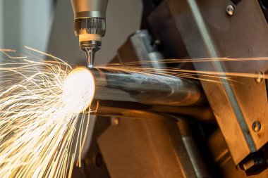 Sahneyi kapatın, fiber lazer kesme makinesi paslanmaz çelik tüpü kesti. Lazer kesme makinesinin yüksek teknoloji metal üretim süreci.. 