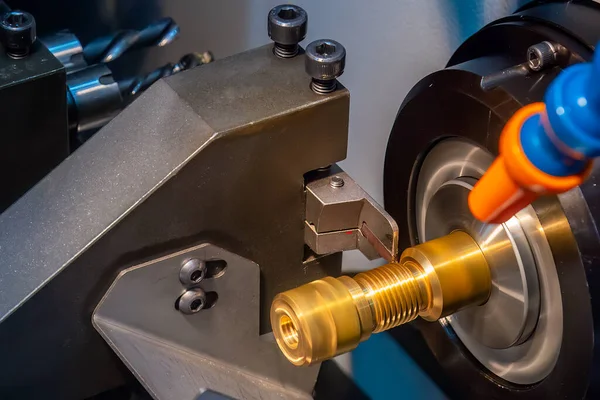 stock image Close up scene the CNC lathe machine thread cutting at the end of brass pipe coupling parts. The hi-technology metal working processing by CNC turning machine .