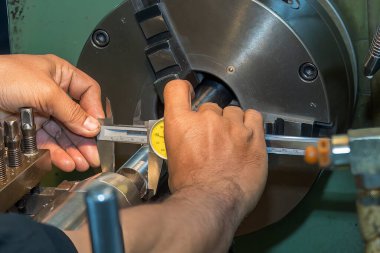 Sahneyi kapatın, makine operatörü Vernier Caliper 'ı çevirerek metal parçalarını ölçüyor. Dönüş makinesinin kalite kontrolü. 