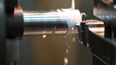 Torna makinesi metal şaft parçalarını sıvı soğutucu metoduyla kesiyor. Makineyi döndürerek metal işleme süreci.