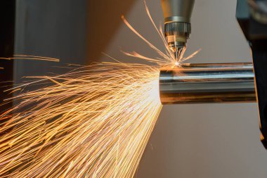 Sahneyi kapatın, fiber lazer kesme makinesi paslanmaz çelik tüpü kesti. Lazer kesme makinesinin yüksek teknoloji metal üretim süreci.. 