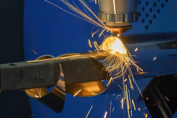 Sahneyi kapatın, fiber lazer kesme makinesi paslanmaz çelik tüpü kesti. Lazer kesme makinesinin yüksek teknoloji metal üretim süreci.. 