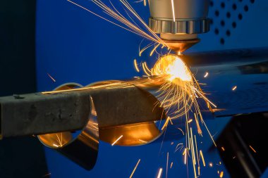 Sahneyi kapatın, fiber lazer kesme makinesi paslanmaz çelik tüpü kesti. Lazer kesme makinesinin yüksek teknoloji metal üretim süreci.. 