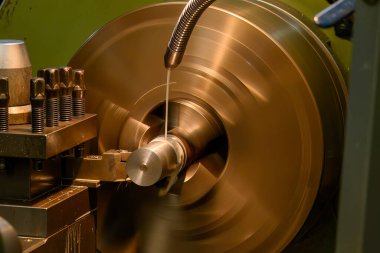 Torna makinesi metal şaft parçalarını sıvı soğutucu metoduyla kesiyor. Makineyi döndürerek metal işleme süreci.