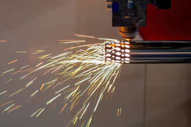 Sahneyi kapatın, fiber lazer kesme makinesi paslanmaz çelik tüpü kesti. Lazer kesme makinesinin yüksek teknoloji metal üretim süreci.. 