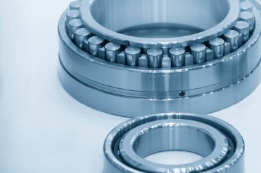 The cylindrical rolling bearing parts in light blue scene. The heavy mechanical part manufacturing concept.