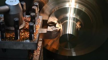 Ağır çekim sahnesi torna makinası pirinç parçalarını çip yerleştirme araçları ile kesti. Makineyi döndürerek metal işleme süreci.