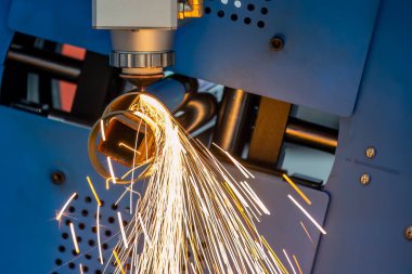 Sahneyi kapatın, fiber lazer kesme makinesi paslanmaz çelik tüpü kesti. Lazer kesme makinesinin yüksek teknoloji metal üretim süreci.. 