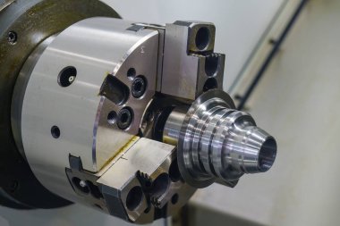CNC torna makinesi metal koni şeklindeki parçaları kesiyor. CNC dönüşüm makinesinin yüksek teknolojili metal işlemesi .