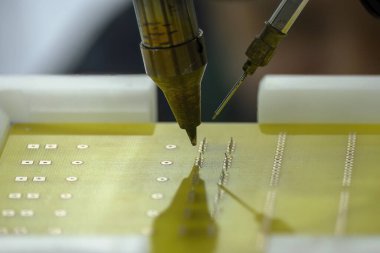 PCB paneli ile otomatik lehimleme makinesi. Robotik sistem tarafından yüksek teknoloji elektronik endüstrisi montaj süreci.