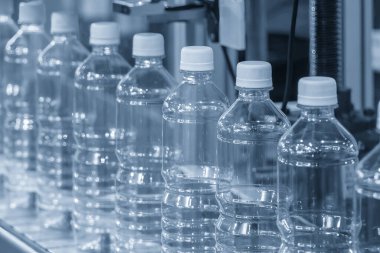 İçme suyu üretim sürecinin yüksek teknolojisi. Taşıma bandındaki boş içme suyu şişelerini doldurmak için.. 