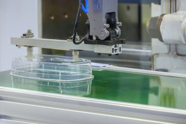 Enjeksiyon makinesinin malzeme işleme süreci kutuyu robot sistemle tutuyor. Plastik işlemden çıkan yiyecek kutusu ürünleri..